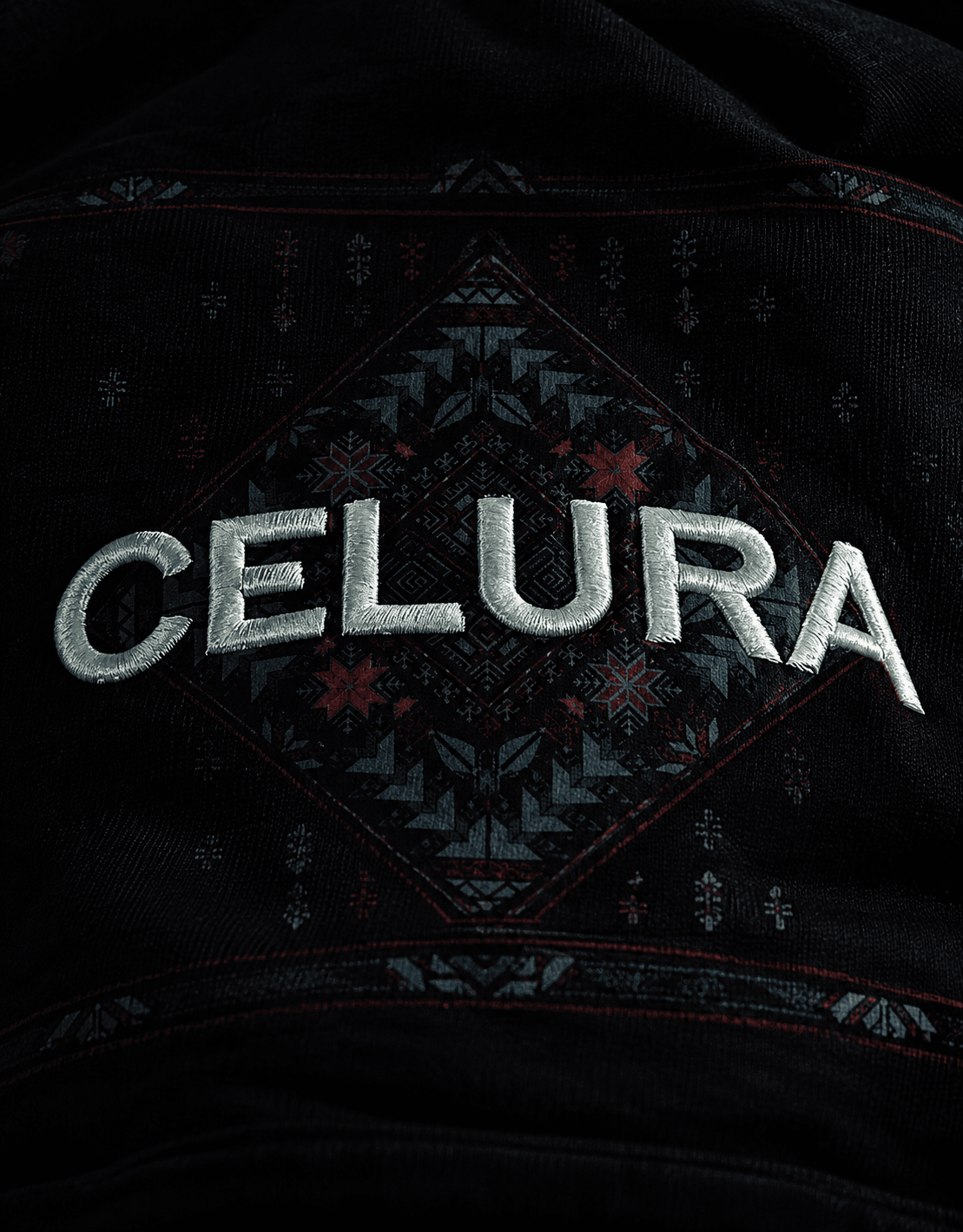 Close-up of embroidered Celura lettering on black fabric