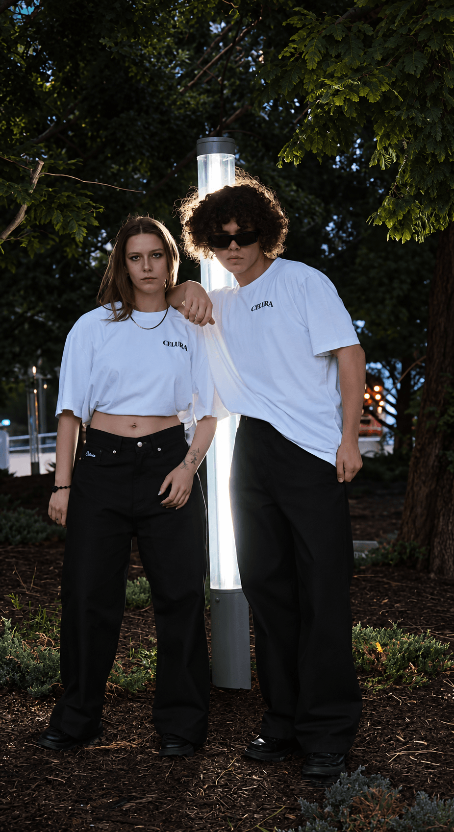 Two models wearing white Celura tees outdoors